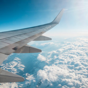 Wing of an airplane flying above the clouds. people looks at the sky from the window of the plane.