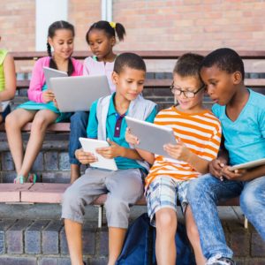 Kids using digital tablet and laptop on bench