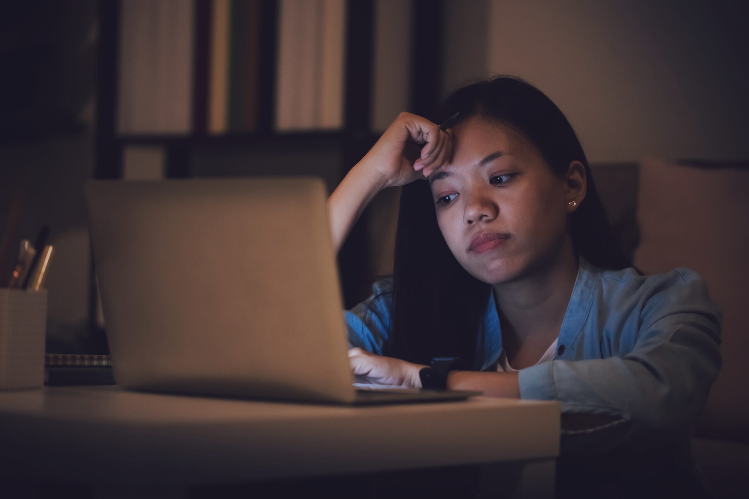Asian woman student or businesswoman work late at night. Concentrated and  feel sleepy at the desk in dark room with laptop or notebook.Concept of  people workhard and burnout syndrome. Asian woman student or businesswoman  work late at night ...